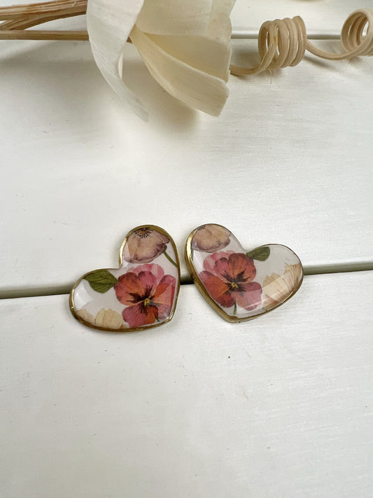 Orecchini a cuore floreali con bordo dorato.