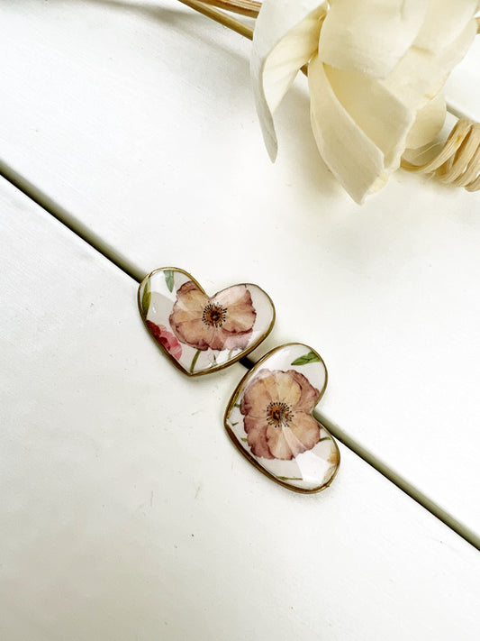 Orecchini a cuore floreali con bordo dorato.